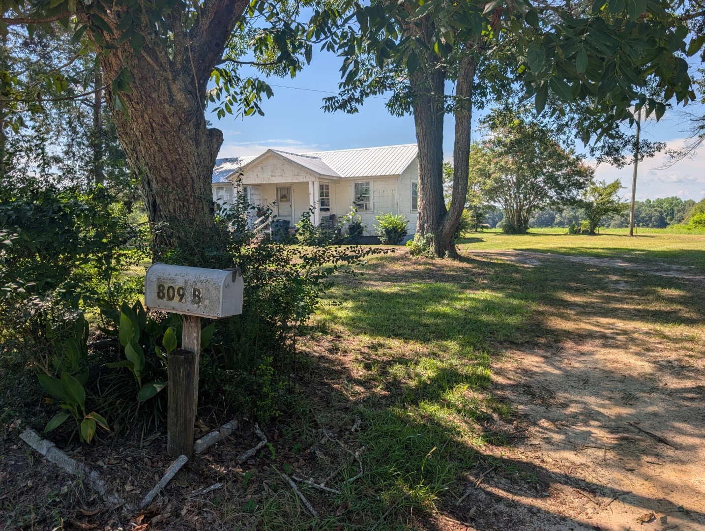 The residence from the dirt driveway, mailbox at the road