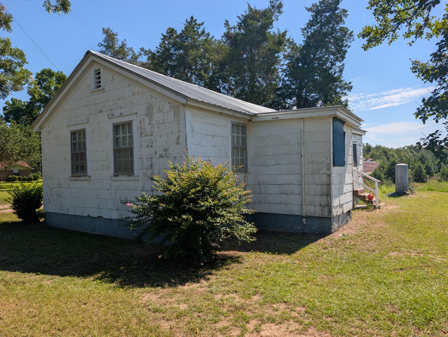 The side and rear of the residence with its metal roof
